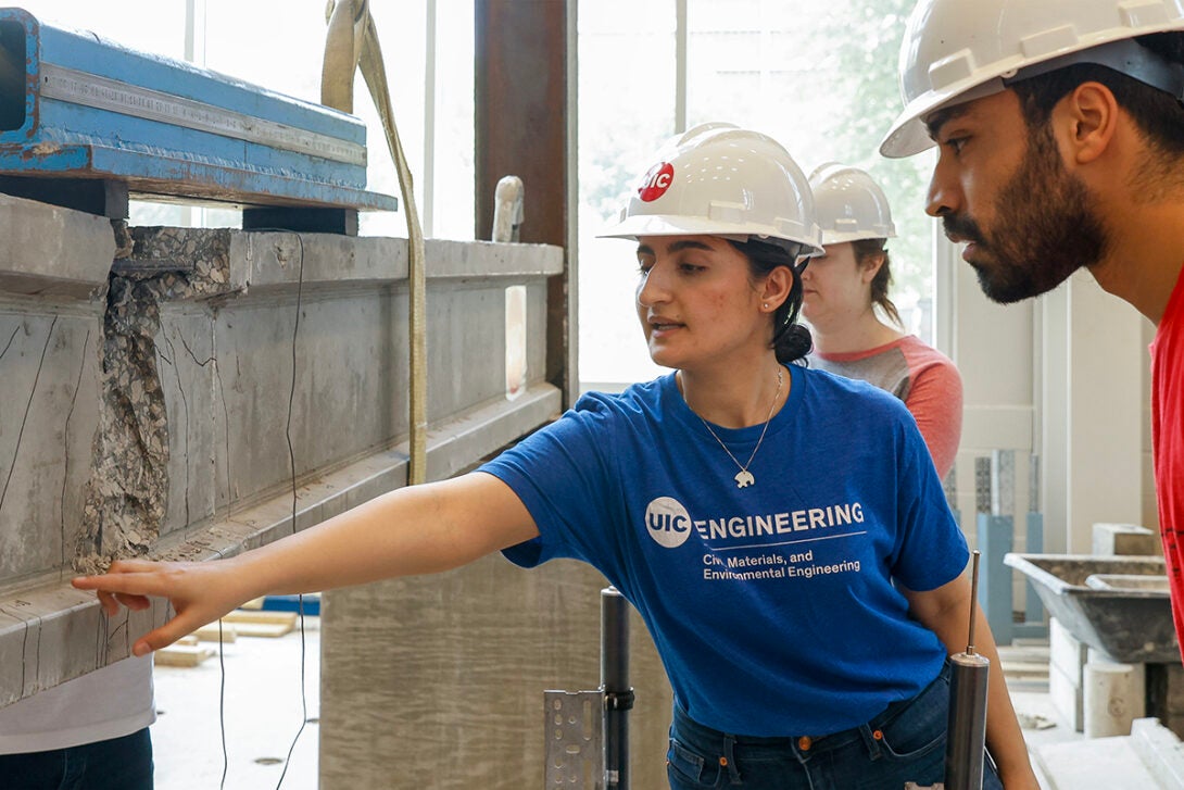 A team of graduate students test a beam in the High-Bay lab at UIC